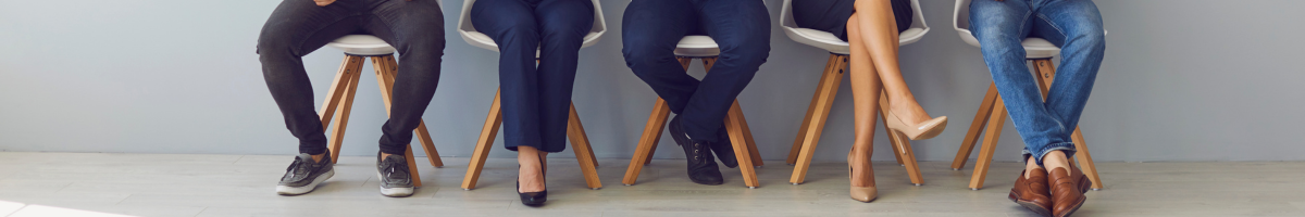 a group of people sitting on chairs with their legs crossed